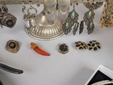 a white table topped with silver jewelry and other items