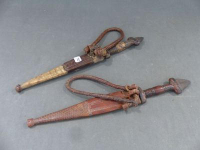 une paire de ciseaux anciens et rouillés posés sur une table, avec une étiquette accrochée au manche