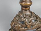 bronze statue of a woman holding a bird on top of a table
