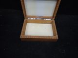 a small wooden box with a glass lid on a black surface