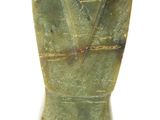 un vase vert posé sur une surface blanche
