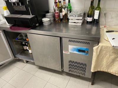 a stainless steel counter with a bunch of bottles on top of it