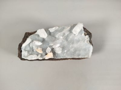 a small piece of rock with white crystals on it