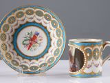 a cup and saucer on a table with a picture of a bird