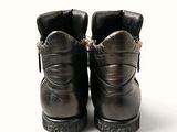 a pair of black leather boots with chains on them