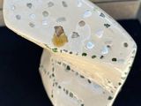 a close up of a white vase with holes in it