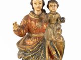 an old statue of a woman holding a child on her lap