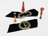 une ceinture noire avec une boucle dorée, une ceinture verte et noire avec une boucle dorée et une ceinture noire et verte avec une boucle dorée