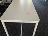 a white table with a pink sticker on it in an office