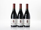three bottles of wine sitting on top of a white table