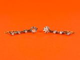 a pair of diamond earrings sitting on top of an orange surface