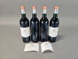 three bottles of red wine sitting on top of a table next to a book