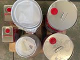 several cans of paint sitting on a pallet next to cans of paint