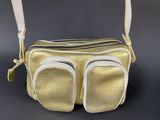 beige and white purse with zippers on a black background