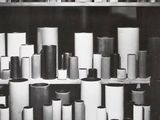 black and white photograph of a shelf full of different types of vases