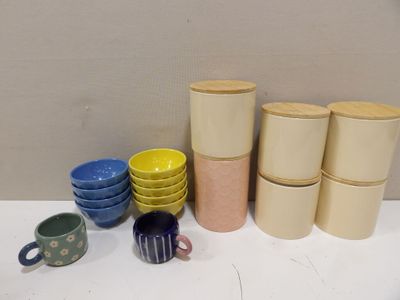 de nombreuses tasses et bols posés sur une table