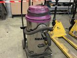 un aspirateur violet posé sur une palette dans un entrepôt
