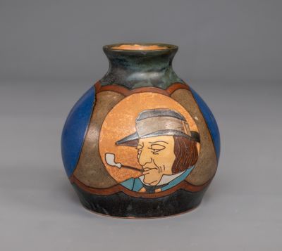 un vase sur lequel figure l'image d'un homme fumant la pipe