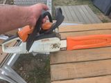 un homme tenant une tronçonneuse sur une table en bois