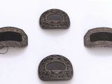 quatre pièces métalliques ornées d'un motif en noir et blanc