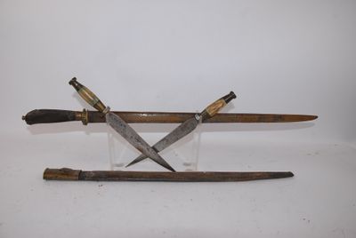 two knives are sitting on top of each other on a white surface