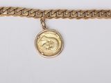 a close up of a gold chain bracelet with a coin on it