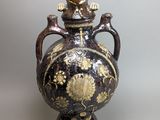 a black and gold vase sitting on a table