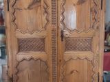 une armoire en bois sculptée, posée à même le sol
