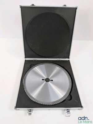 a metal case with a disc in it on a white surface