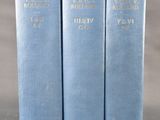 trois livres bleus posés les uns à côté des autres sur une table