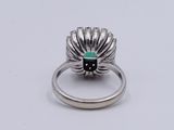 an image of a silver ring with a green stone in the center