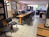 une pièce équipée d'un bureau, de chaises et d'une télévision