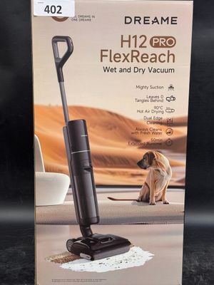 the box of a vacuum cleaner with a dog sitting on the floor