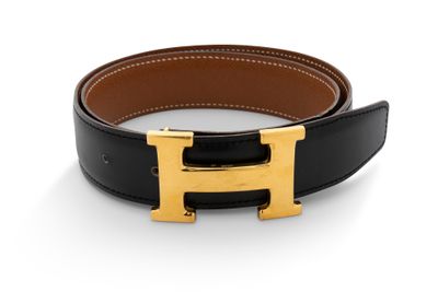 une ceinture en cuir noir avec une boucle en forme de « H » dorée