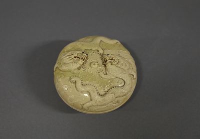 un petit vase vert orné d'un dragon