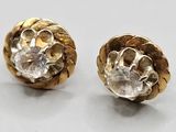 two pairs of gold and diamond earrings on a white surface