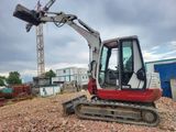 a picture of a small excavator sitting on a pile of rubble