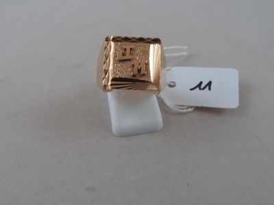a gold ring on a white surface with a price tag