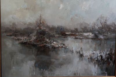 un tableau accroché au mur d'une pièce où se trouve un tableau représentant une rivière