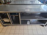 a stainless steel work table with a shelf on the side
