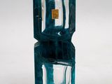 a blue glass vase with a small glass inside of it
