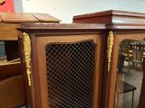 a wooden cabinet with a glass door on top of it