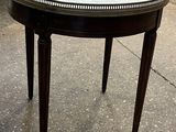 une petite table avec un plateau en marbre posée sur le trottoir