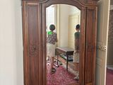 a large wooden armoire with a mirror on top of it