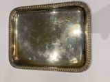 a silver tray on a wall with a mirror above it
