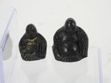 two small statues of buddhas on display in a glass case
