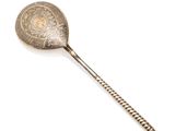 une cuillère ancienne avec un manche en métal sur fond blanc