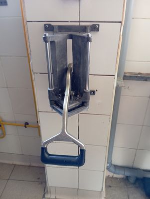 a toilet with a metal handle in a bathroom stall