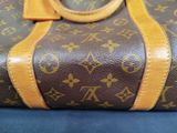 a brown and tan bag with a ring on it