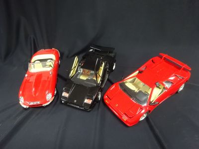 three toy cars that are sitting on a black surface